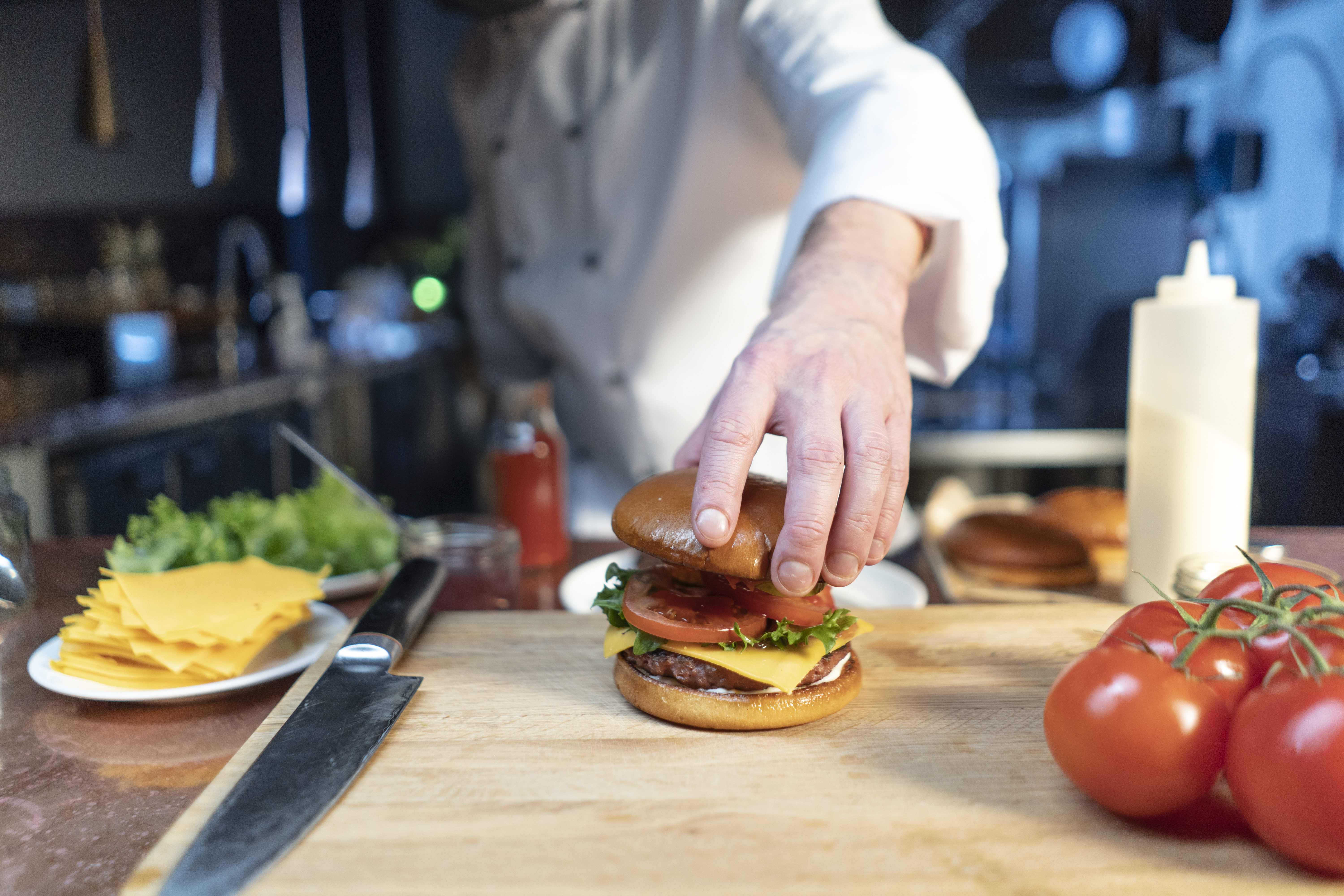 Chef che assembla un hamburger