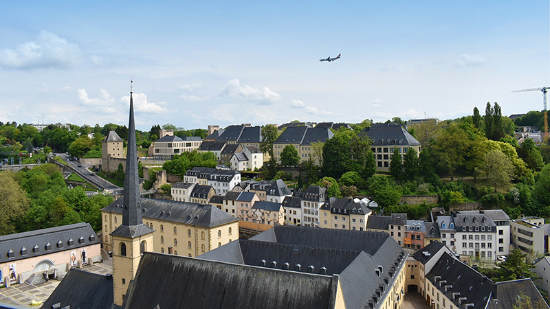 View of Luxembourg with plane flying in the sky