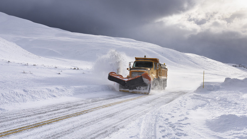 Yellow snow plow clearing snow