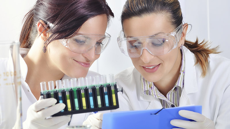 Two scientists with indicators and test results for microbial levels