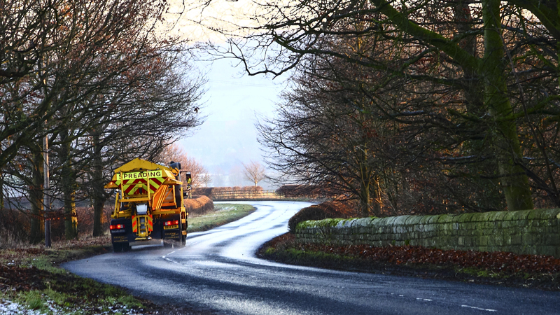 Council gritter spreading salt on a rural road in Wharfedale Yorkshire England UK