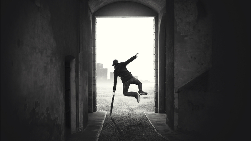 A man jumping with an umbrella