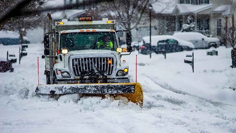 Snowplow truck clearing residential roads
