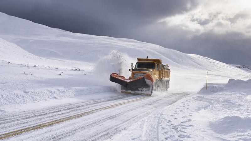Yellow snow plow clearing snow