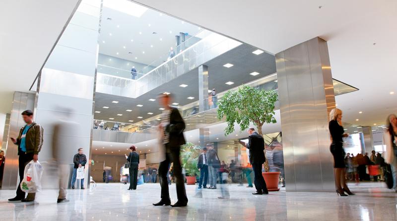 People walking through a building lobby.