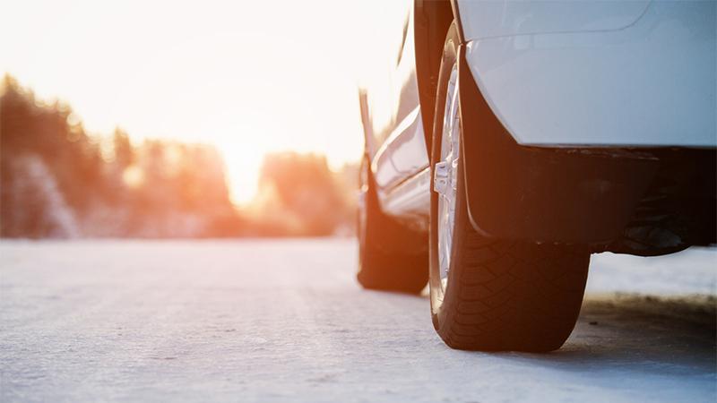 White car on a winter road through a snow covered forest. Bottom view