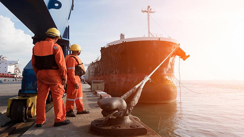 Men at sea port with a ship on the background