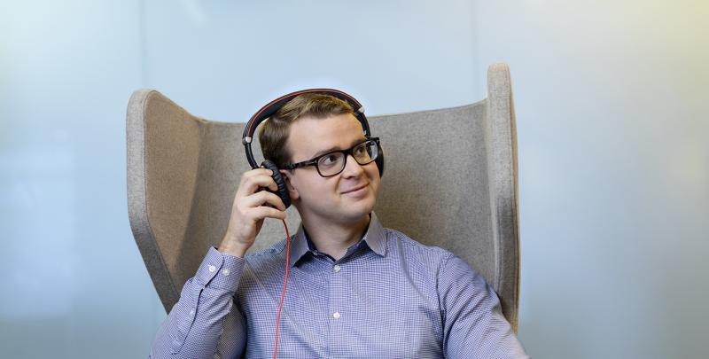 A man sitting in a chair with headphones on.