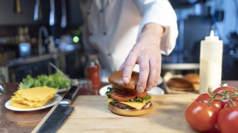Chef che assembla un hamburger