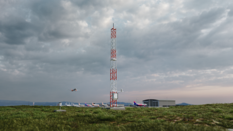 AWS810 pictured at airport with plane flying in the background.