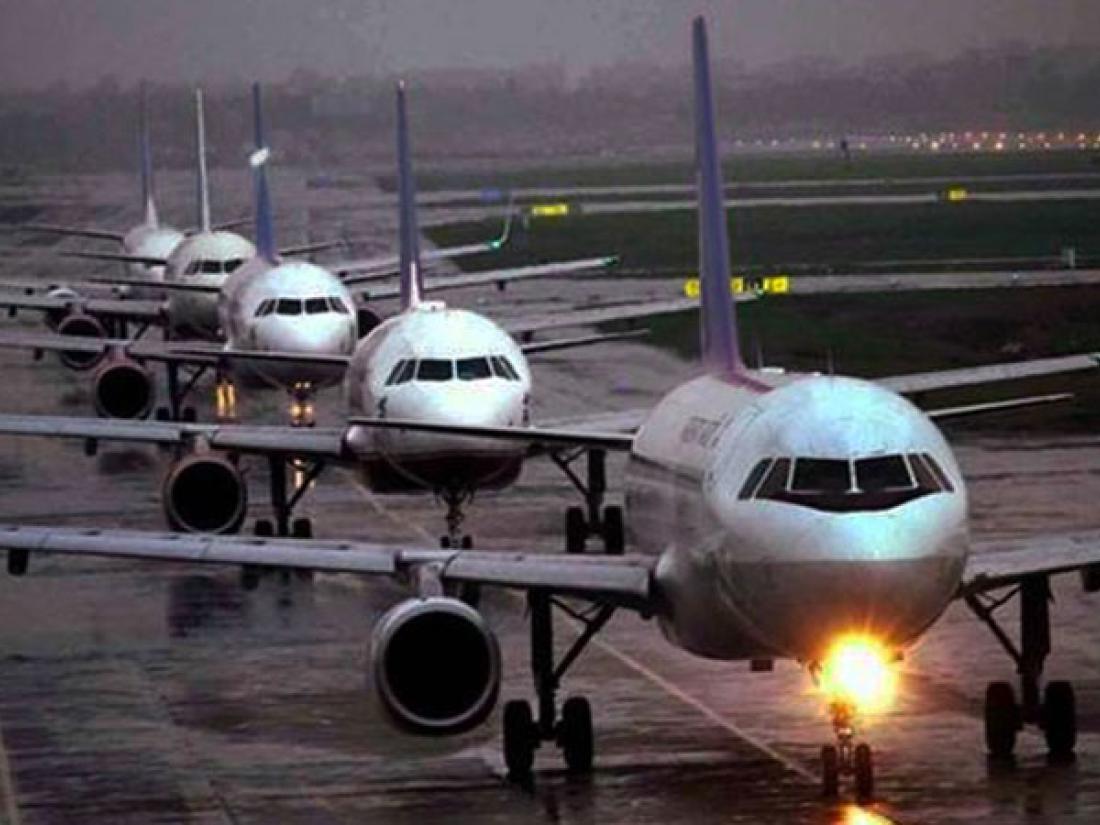 Planes backed up on a wet runway in rain