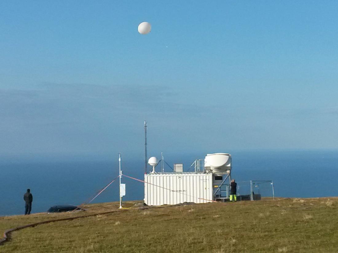 海を背景にラジオゾンデを空に放球するヴァイサラのサウンディングシステム