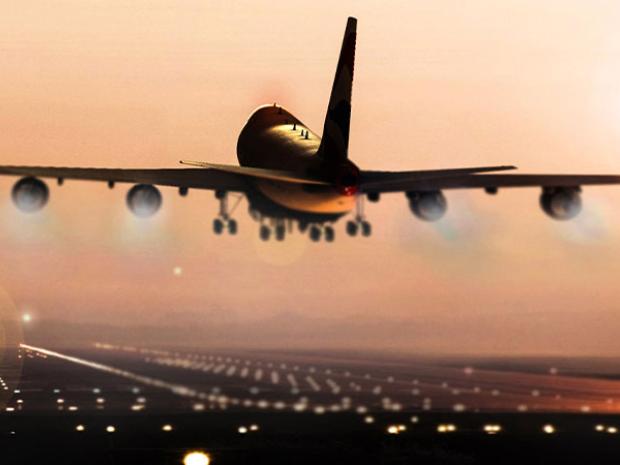 Airplane taking off at sunset