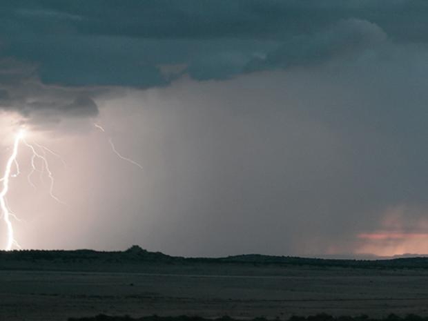 Landscape scenery with lightning and storm clouds over hills