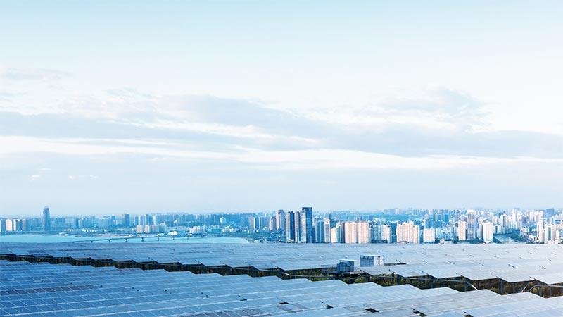 Solar panel field with city in background