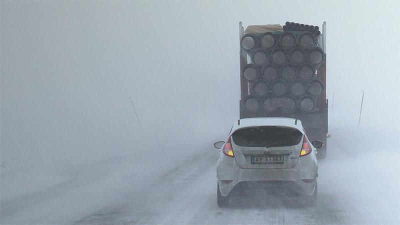 Car driving behind a log truck in poor visibility