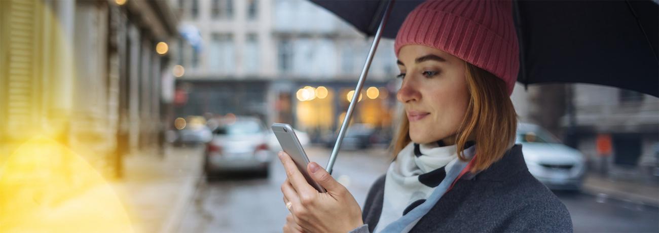 Woman in the rain with mobilephone