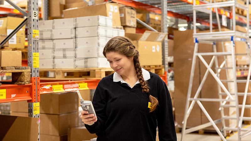 Worker holding HM40 in warehouse.