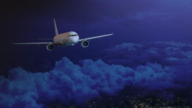 Passenger jet wide body plane in the dark night sky. Airplane flying high above the night Earth.