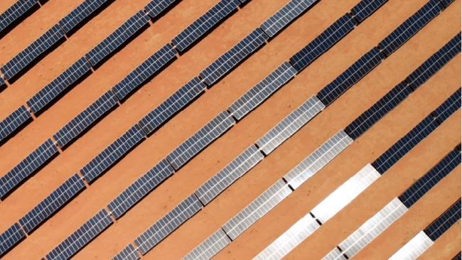 Close aerial view of rows of solar panels in a desert 