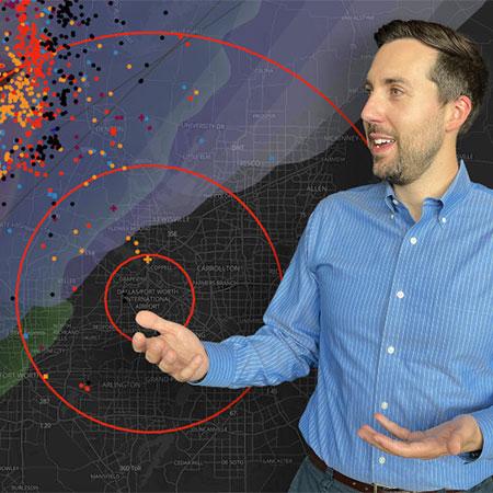 Hans Loewenheath stands in front of a map showing lightning activity around Dallas Fort Worth airport