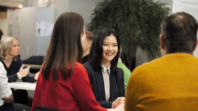 People meeting, discussing and smiling in an office area.