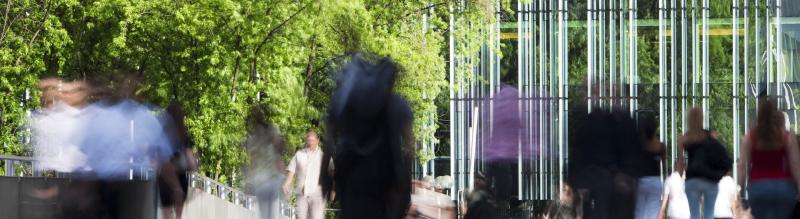 People walking outside in front of an office building.