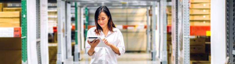 Woman reading a tablet in a warehouse