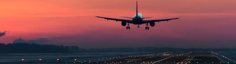 Airplane taking off at sunset