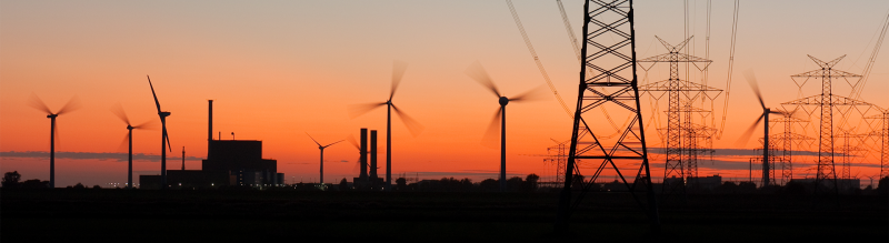 Power lines, pylons & wind turbines against evening sky
