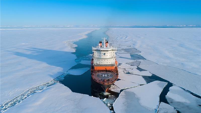 Icebreaker with helideck pictured from above in action breaking ice.