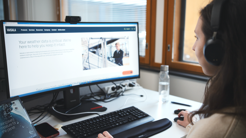 Employee browsing Vaisala Care website on desktop with headset