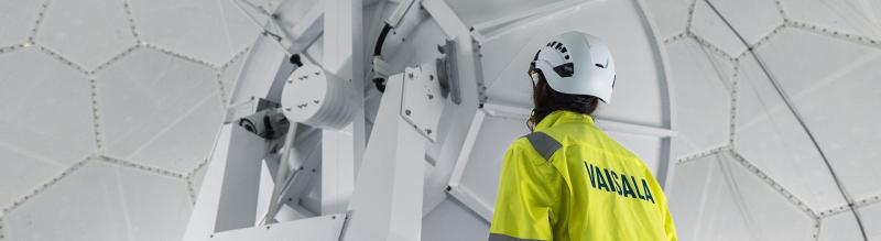 Inside Vaisala weather radar with technician.