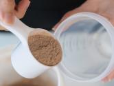 Woman pouring protein powder into a cup