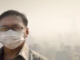 A man wearing a mask due to the smog in a city
