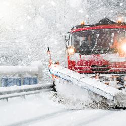Snow plow driving in winter weather