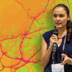 Laura Alku stands in front of a city map showing air quality index levels from Vaisala Xweather