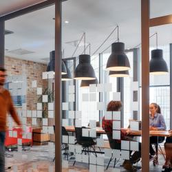 A group of business professionals walk down the corridor next to their office