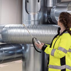 Person holding HM40 with HVAC ventilation ducts in the background.