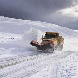 Yellow snow plow clearing snow
