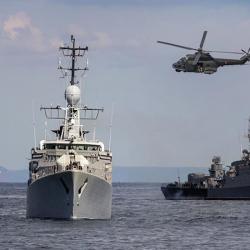 Military vessels at sea with helicopter above