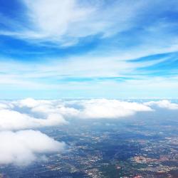 Sky, clouds and a city below (aerial view)