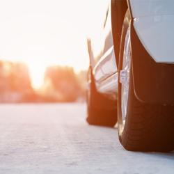 White car on a winter road through a snow covered forest. Bottom view