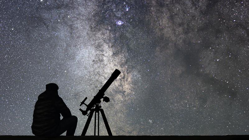 Exploring space Man with telescope watching space